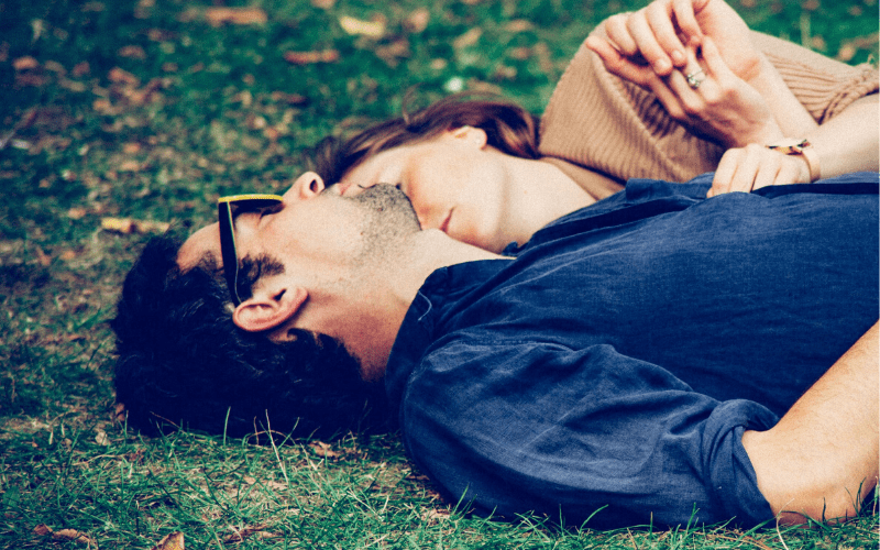 男女が公園で寝ている画像